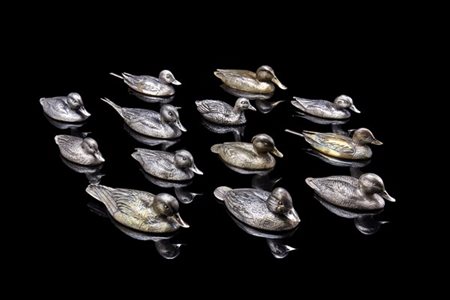 Tredici sculture in argento raffiguranti diverse specie di anitre di misure dif