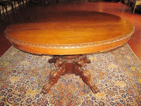 Tavolo con gambe leonine a treppiede, allungabile a dieci posti. Legno. .