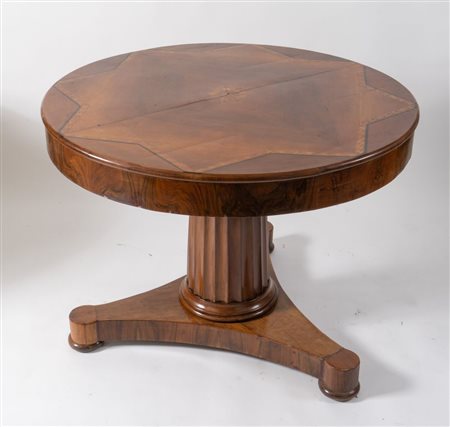 Tavolo tondo lastronato in noce con filetto intarsiato a motivi geometrici....