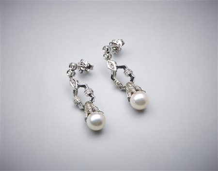  . - Orecchini pendenti in oro bianco 750/1000 con coppia di perle sferiche bianche coltivate di mm 8,50 e piccoli diamanti bianchi di taglio misto di 0,80 ct. circa.