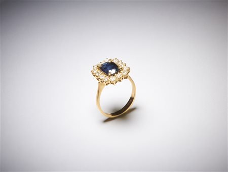  . - Anello in oro giallo 750/1000 con contorno di diamanti tondi taglio a brillante di 1,00 ct circa H/I VS  e zaffiro blu  centrale taglio a cuscino di 3,00 ct circa. .