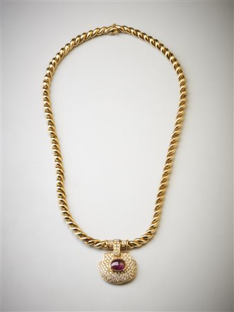  . - Collana in oro giallo 750/1000 maglia intrecciata con ciondolo con pavè di diamanti bianchi taglio brillante carati 2,80  ca. e rubino ovale cabochon di  4,50 carati circa.