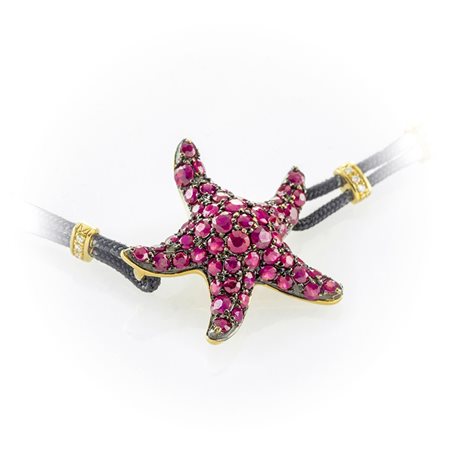 Bracciale in cordino nero con stella marina impreziosita da pavè di rubini. Quattro inserti in oro giallo e diamanti taglio brillante sul cordino. 