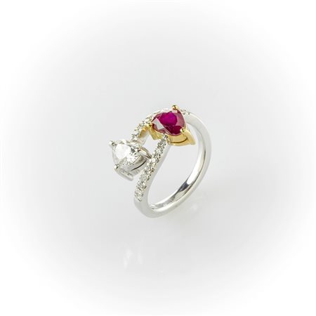Anello contrariè in oro bianco e giallo con un diamante e un rubino taglio a cuore contrapposti e pavè di diamanti sul gambo