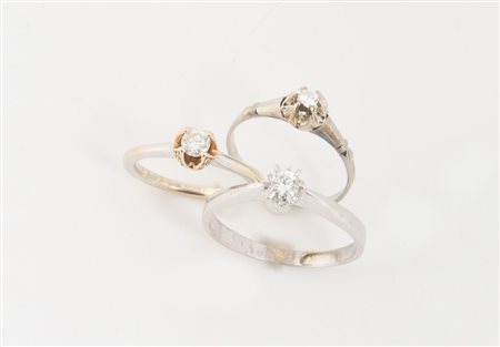 TRE ANELLI CON DIAMANTI In oro bianco e rosa, ciascuno centrato da diamante...