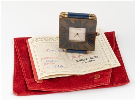 CARTIER SVEGLIA DA TAVOLO Cassa di forma quadrata in metallo dorato, fondello...