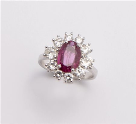 ANELLO IN ORO, RUBINO E DIAMANTI In oro bianco, centrato da rubino ovale...