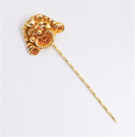 SPILLONE IN ORO In oro giallo, sormontato da mascherone recante la firma...