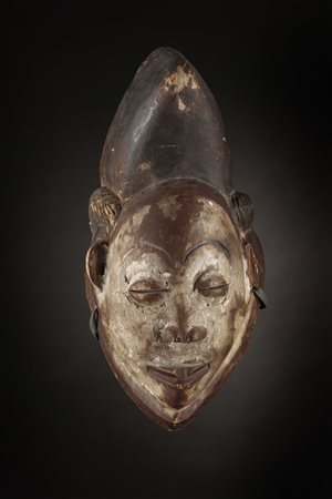  Arte africana - Gabon, Regione del fiume Ngouniè - Punu.
Maschera Mukudj.
Legno tenero a patina naturale, caolino e pigmenti.
Mancanze e segni d'uso.