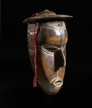  Arte africana - Nigeria, Urhobo 
Maschera Urhobo in legno con cappello,
Legno, capelli.
Segni  e patina d'uso. .