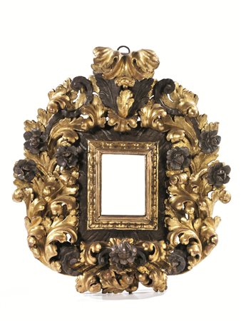 Cornice, secolo XVIII, in legno riccamente intagliato ad ampie volute di...