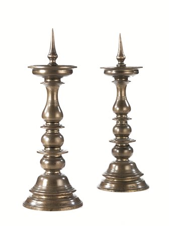 Coppia di portaceri, sec. XVII, in bronzo con fusti torniti, basi circolari,...