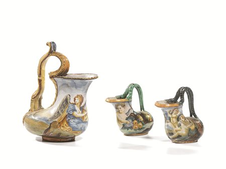 Coppia di piccoli versatoi, sec. XVIII, in maiolica, decorata con putti, anse...