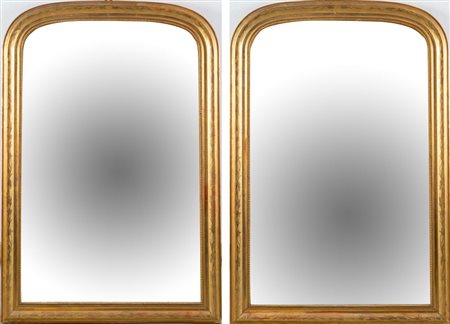 Coppia di specchiere a ferro di cavallo, con cornice modanata e dorata....