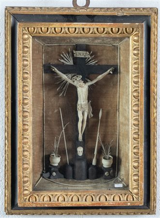 Teca contenente crocifisso in materiale prezioso e alla base i simboli della...