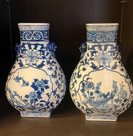 Coppia di vasi in porcellana bianca e blu decorati con motivi floreali e prese