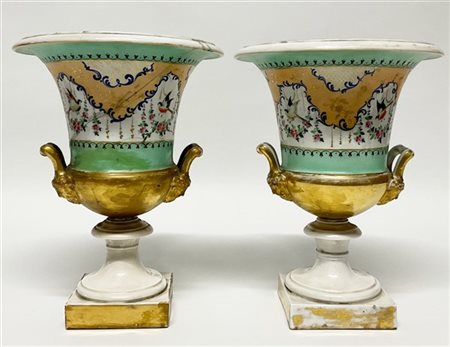 Coppia di vasi in porcellana biansati con attaccature a teste virili, decori a