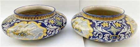 Coppia di cache-pot in ceramica policroma con decoro a putti e volute fiorite s