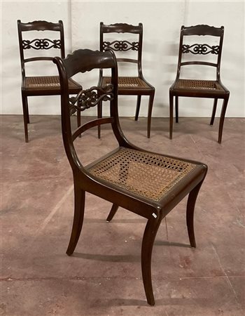 Quattro sedie con schienale centrato da cartella intagliata, gambe a sciabola e