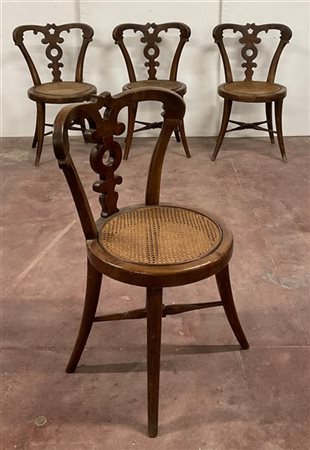Quattro sedie in legno intagliato con schienale sagomato e seduta circolare in