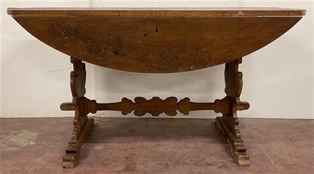 Tavolo fratino ad alette in legno tinto con piano ovale, gambe sagomate riunite