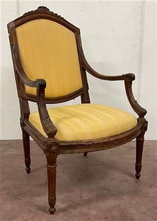 Poltrona Luigi XVI in noce con braccioli intagliati a volute fogliate, gambe ra