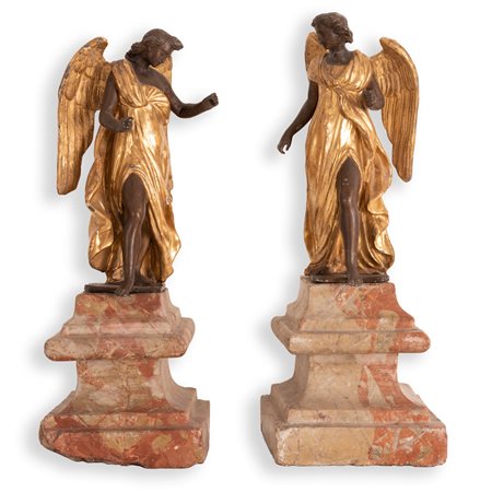 Manifattura Romana del XVIII secolo   Coppia di sculture in metallo brunito e dorato raffiguranti angeli su antiche basi in marmo 