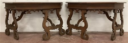 Coppia di console sagomate con gambe a lira riunite da traverse formanti tavolo