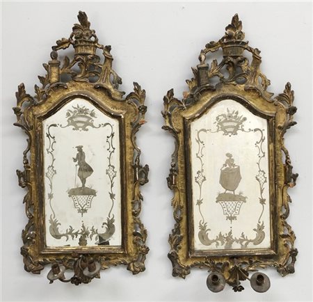 Coppia di specchiere in legno intagliato, traforato e dorato a volute fiorite,