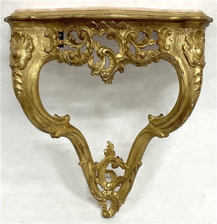 Coppia di console pensili di forma mossa in legno intagliato e dorato a volute