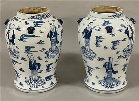 Coppia di vasi in porcellana bianca e blu decorati con figure degli otto immort