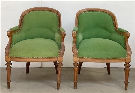 Coppia di poltrone a pozzetto in legni vari. Gambe anteriori tornite. Braccioli