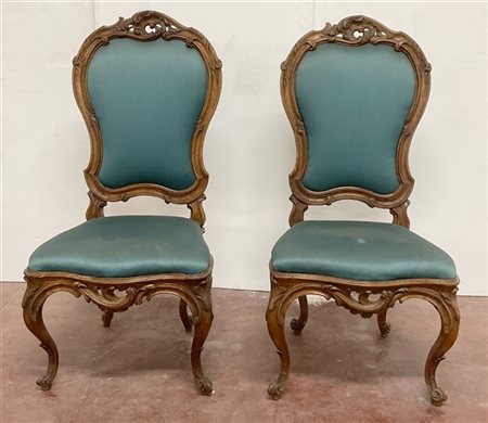 Coppia di sedie in legno intagliato e traforato a volute fogliate. Fascia e gam