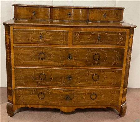 Cassettone di forma mossa in noce lastronato, filettato e intarsiato con fronte