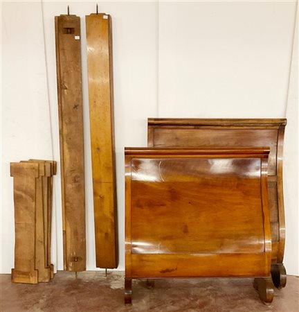 Coppia di letti a barca in noce con piedi intagliati a ricciolo. Secolo XIX