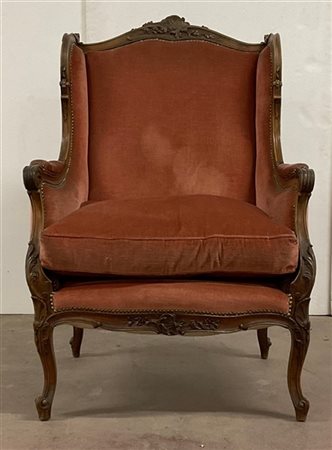 Poltrona in legno intagliato con profili mossi, cuscino e imbottiture rivestite