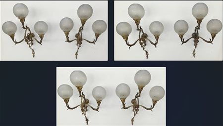 Gruppo di sei applique a tre fiamme in metallo dorato decorato a volute fogliat