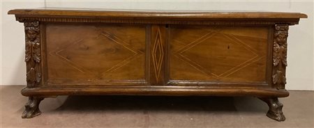 Cassapanca in noce con fronte intarsiato a motivi geometrici. Montanti intaglia