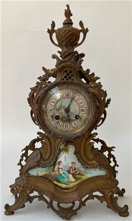 Orologio d'appoggio con cassa in metallo dorato decorata a motivo rocaille. Qua