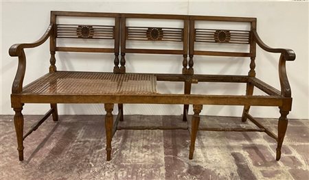 Divano in noce con schienale a giorno, cartelle intagliate con rosone centrale.