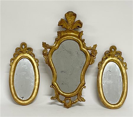 Lotto composto da tre specchierine in legno intagliato e dorato a volute, fiori