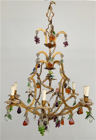 Lampadario con struttura in metallo dorato a otto fiamme con pendenti e applica