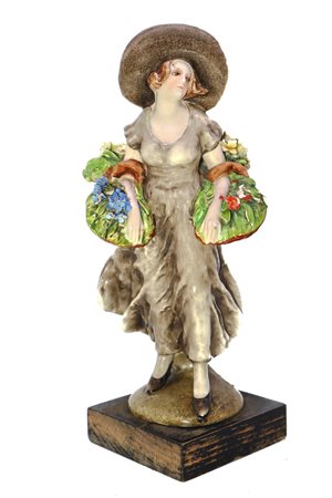 Statuina in ceramica raffigurante dama con cesto di fiori