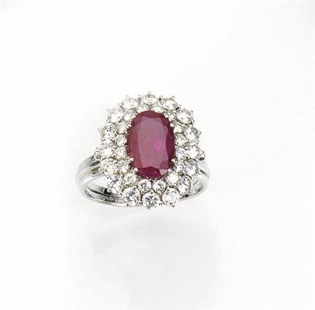 Anello in oro bianco, rubino e diamantial centro rubino ovale montato entro...