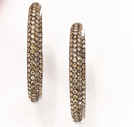 Paio di orecchini in oro bianco e diamanti gialliciascuno disegnato come un...