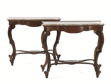 Coppia di consoles, sec. XIX, in noce, piano sagomato in marmo, gambe mosse...