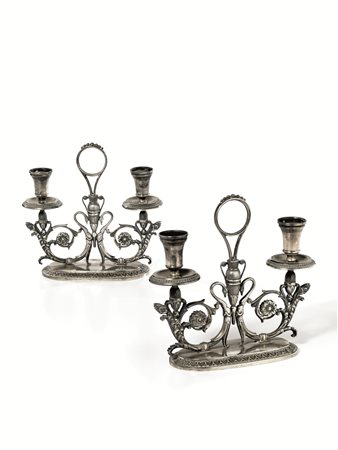 Coppia di candelabri, in argento, corpo configurato a volute vegetali e...