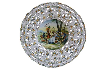    Grande piatto traforato realizzato per la Simac di Castelli con decoro floreale sulla tesa e scena di cattura del Faraone nel cavetto.  