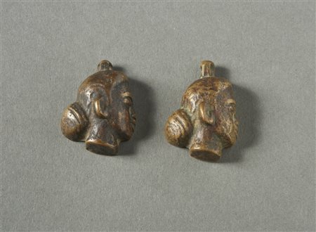  Arte Indiana - India. 
Due pendenti a forma di testa femminile in lega di rame. 
In patina. .