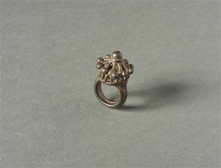  Arte Indiana - India. 
Anello in lega di rame con decorazioni geometriche a gabbia e sonaglio in pietra. 
In patina.